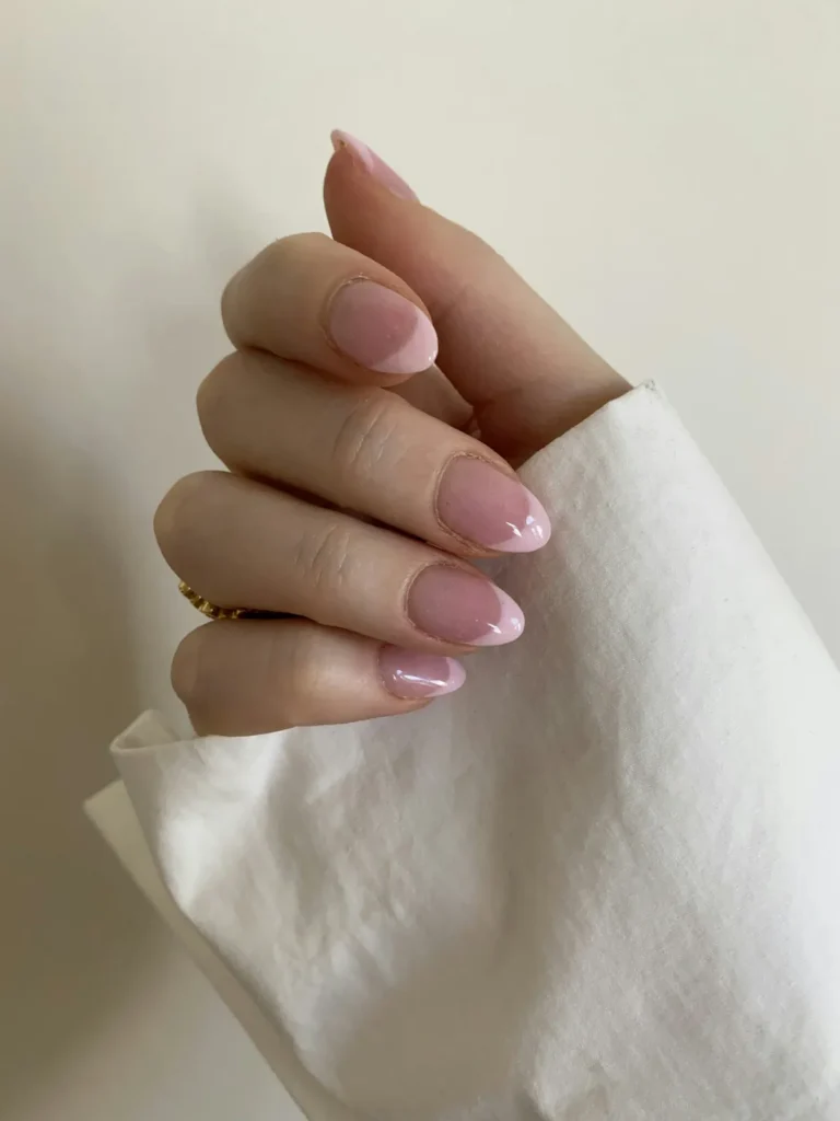 Sheer pink almond nails on white paper