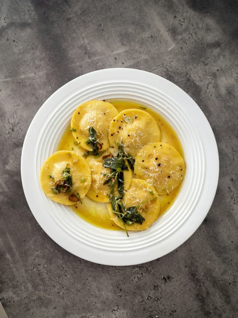 Ravioli with sage butter on a white plate