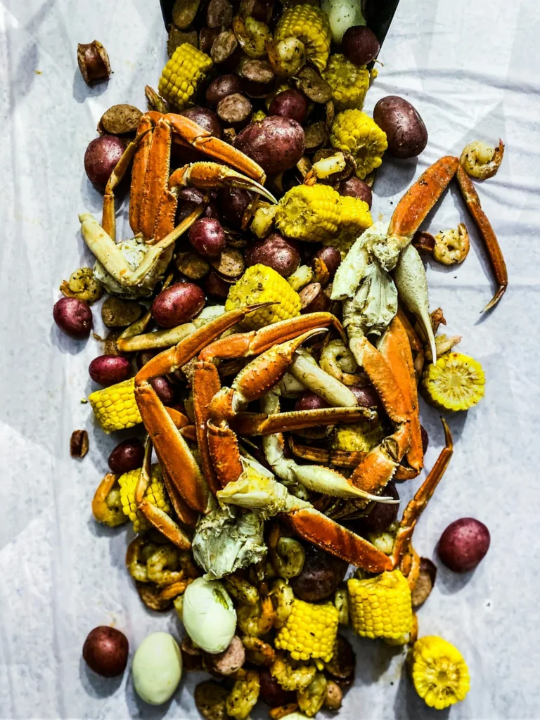 Crab legs, corn and potatoes poured on the table