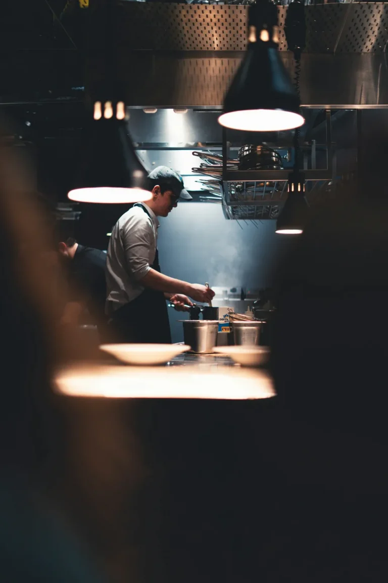 Cook at the stove under warm lamps