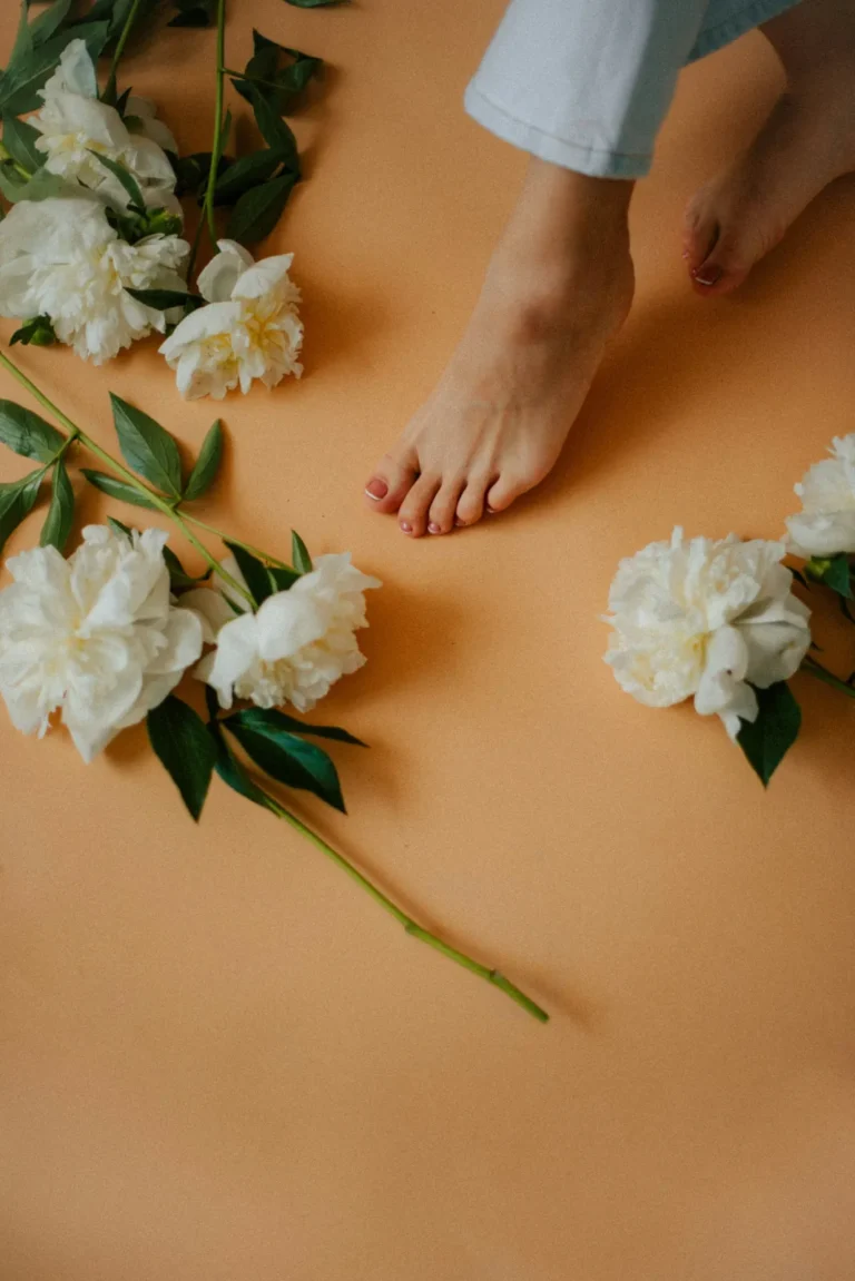 Feet and peonies on an orange floor