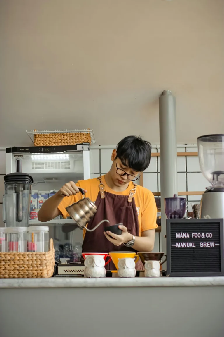 Barista pouring water over the grounds