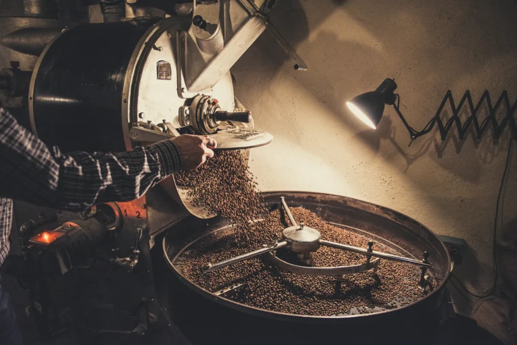 Coffee roaster at work under a lamp