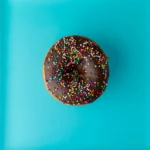 Chocolate sprinkle donut on blue