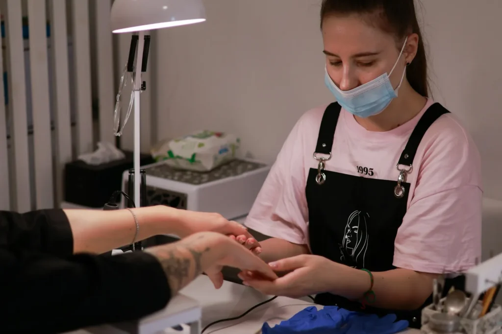Nail technician at work in a mask