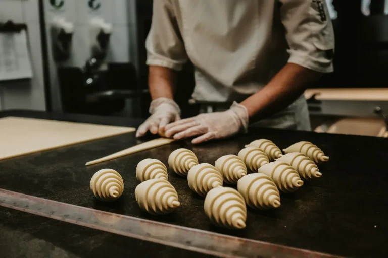 Baker shaping croissants by hand