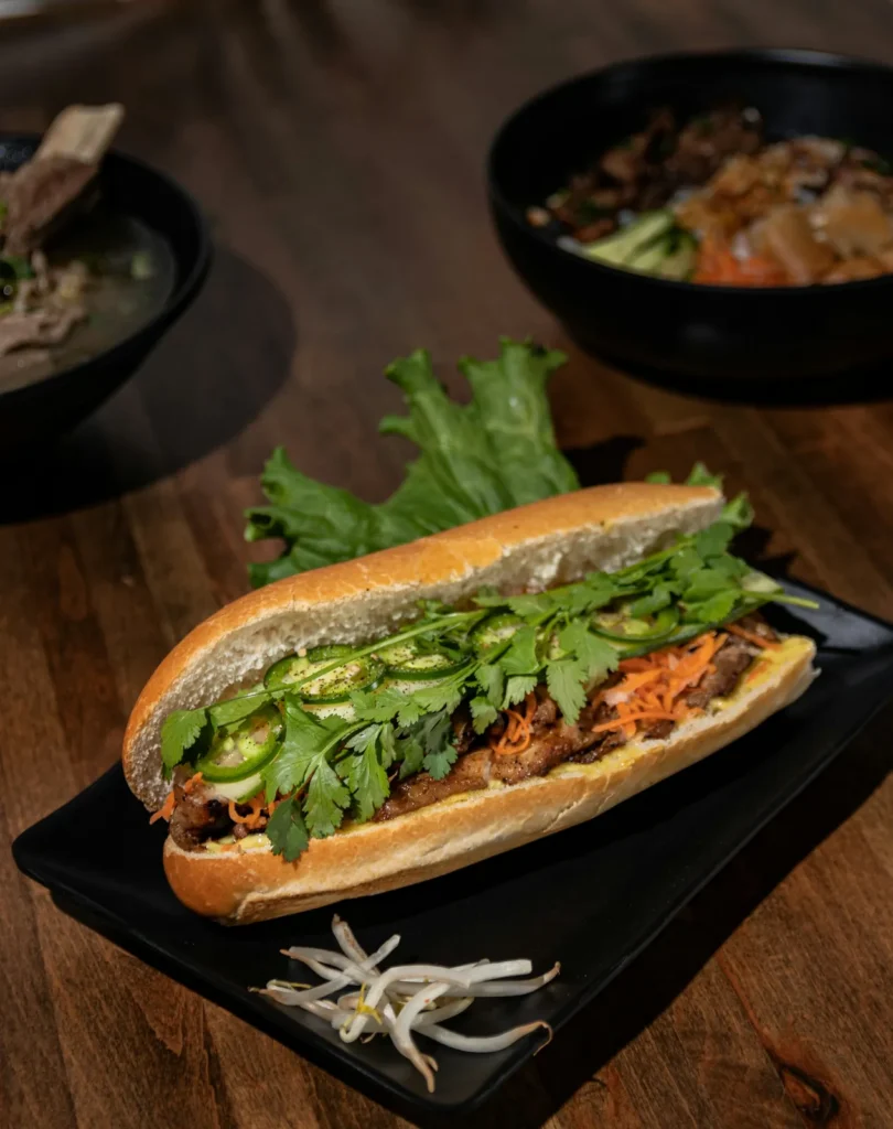Banh mi with herbs and jalapeño on a black slate