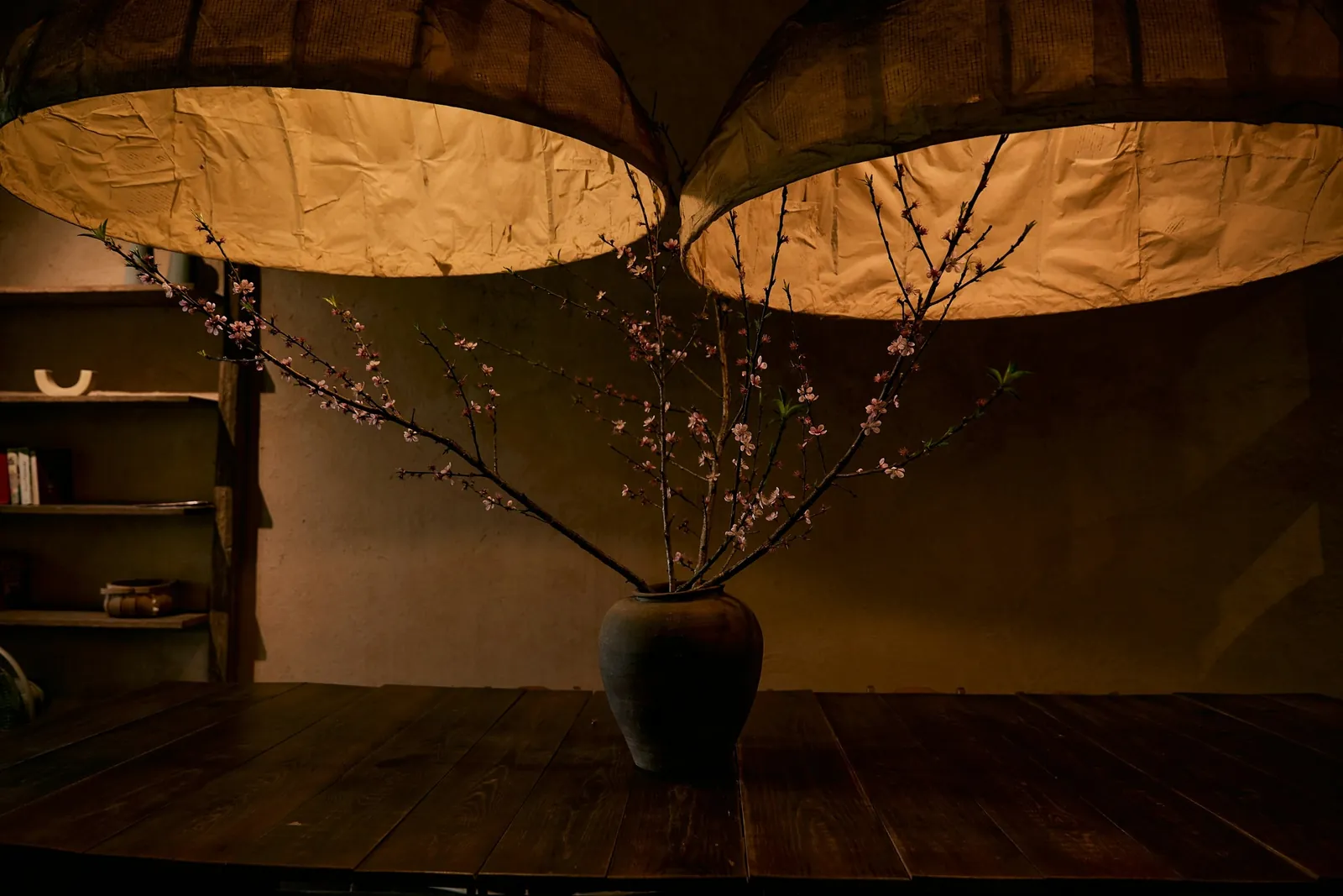 Paper lanterns over a dining table with a blossom branch