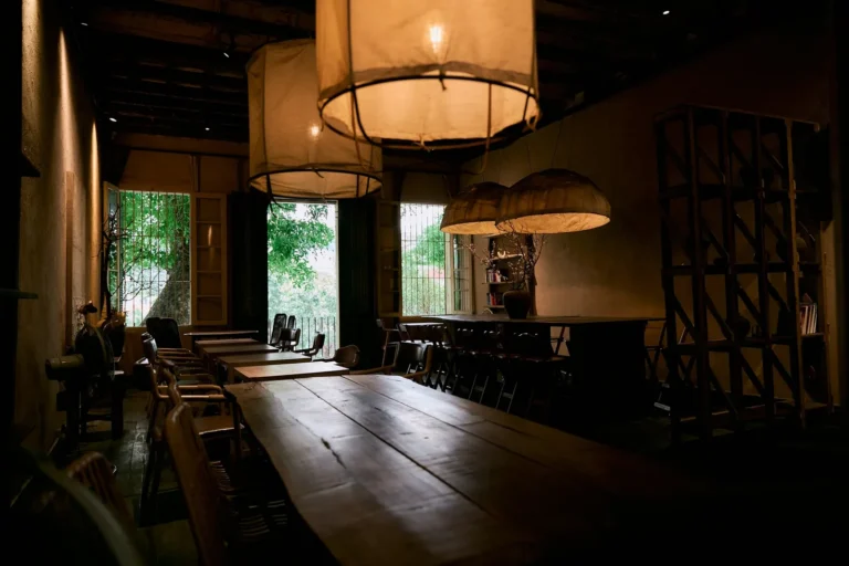 Dining room with long wooden tables and pendant lamps