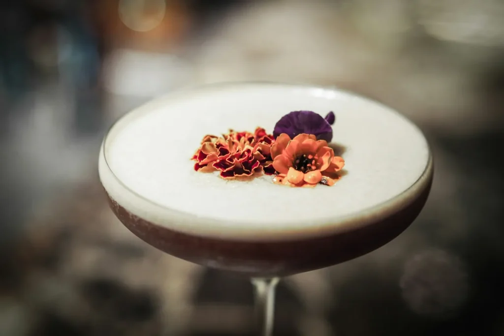 Foamy cocktail topped with dried flowers