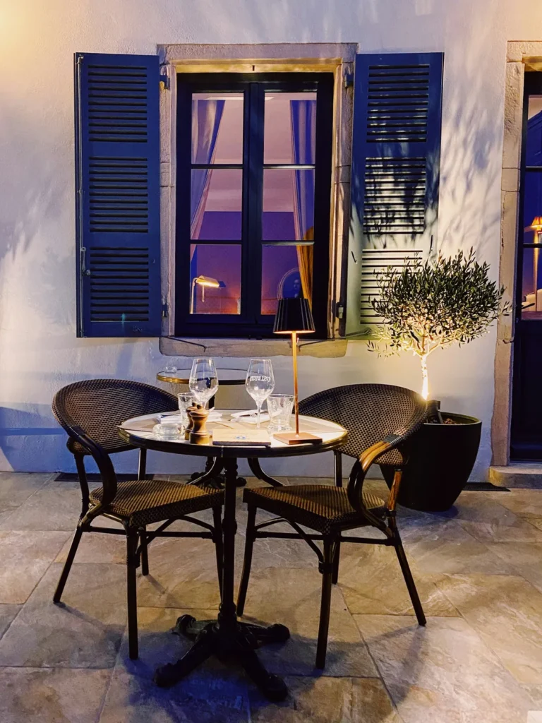 Table for two by a window with blue shutters