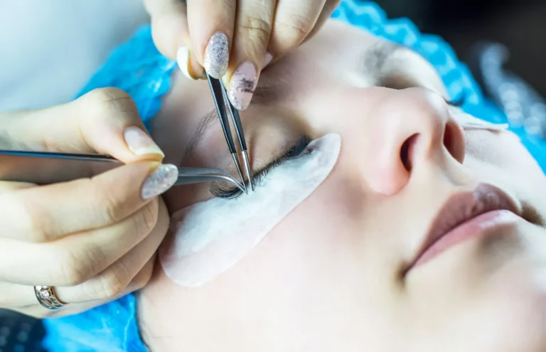 Two pairs of tweezers isolating a lash