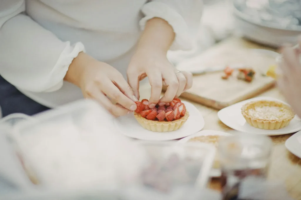 Pastry chef placing strawberries on a tart