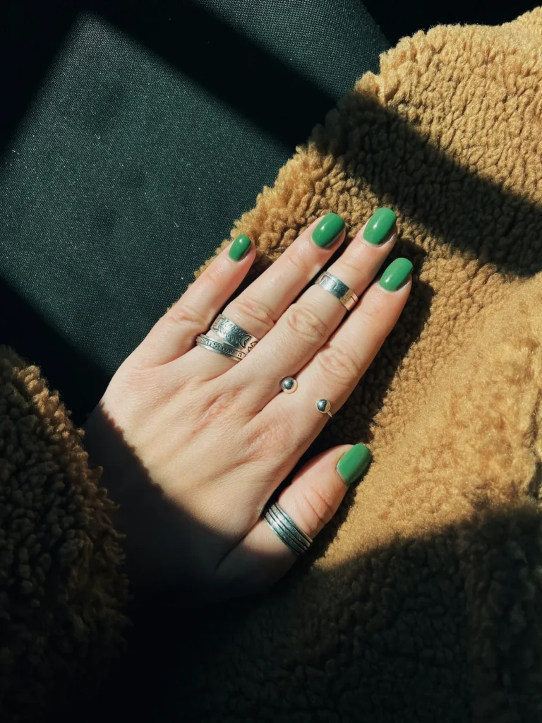 Short green nails with silver rings