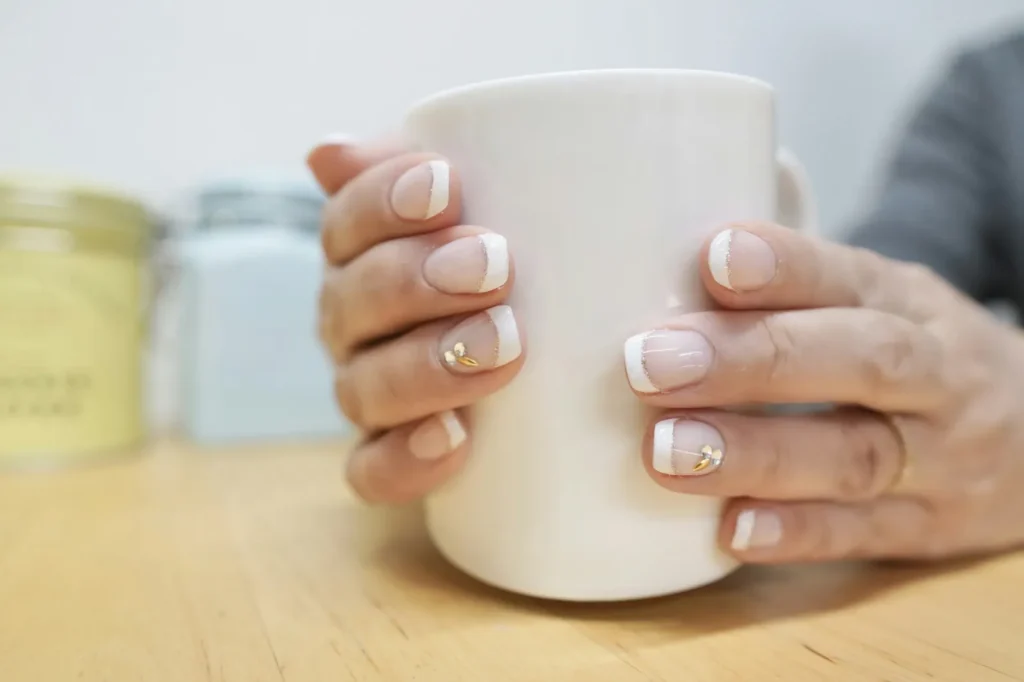 Short French manicure with gold details
