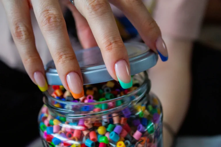 Colorful French tips on a jar of beads