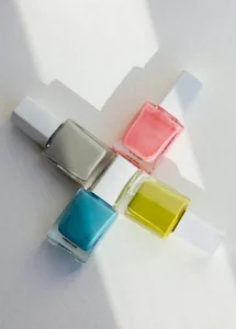 Four bright polish bottles crossed on white