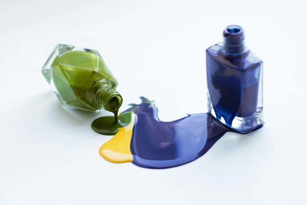 Green, yellow and blue polish spilled on white