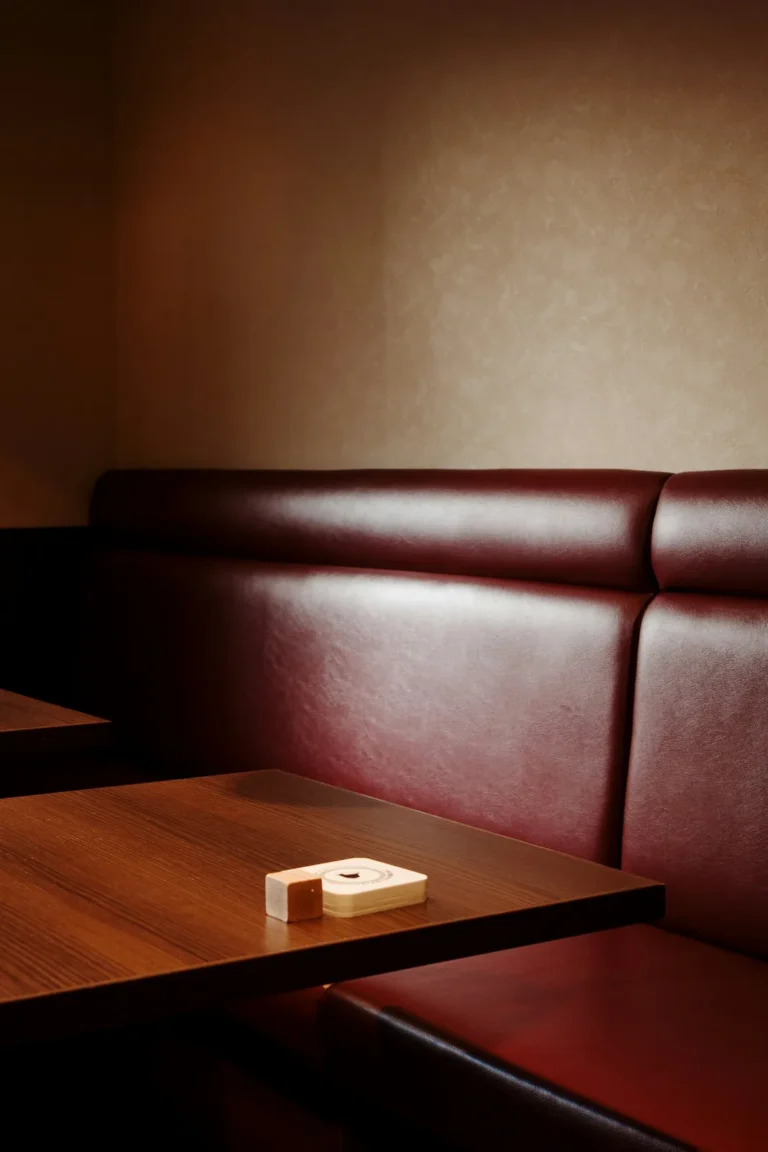 Oxblood leather banquette beside a wooden table