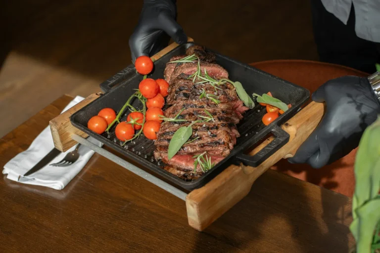 Sliced steak served on a cast-iron board