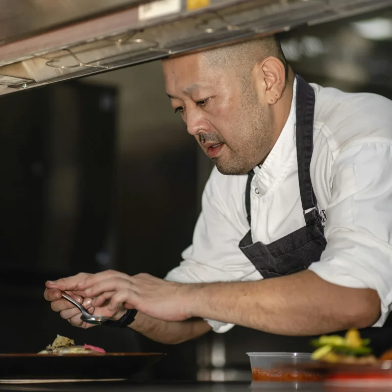 Chef plating a dish at the pass