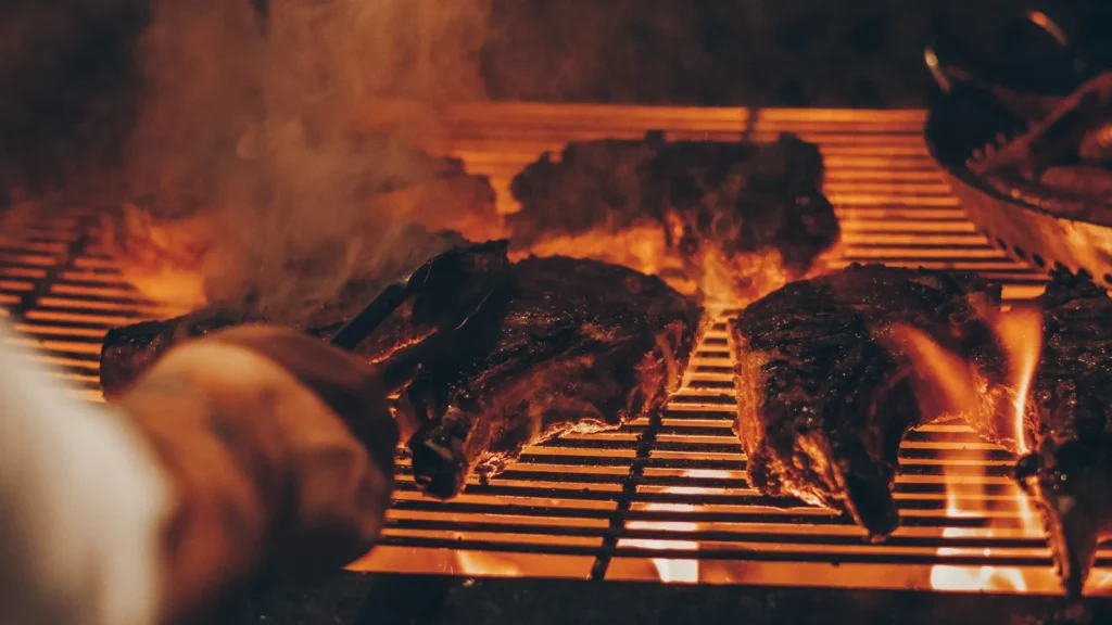 Steaks on the grill over glowing embers