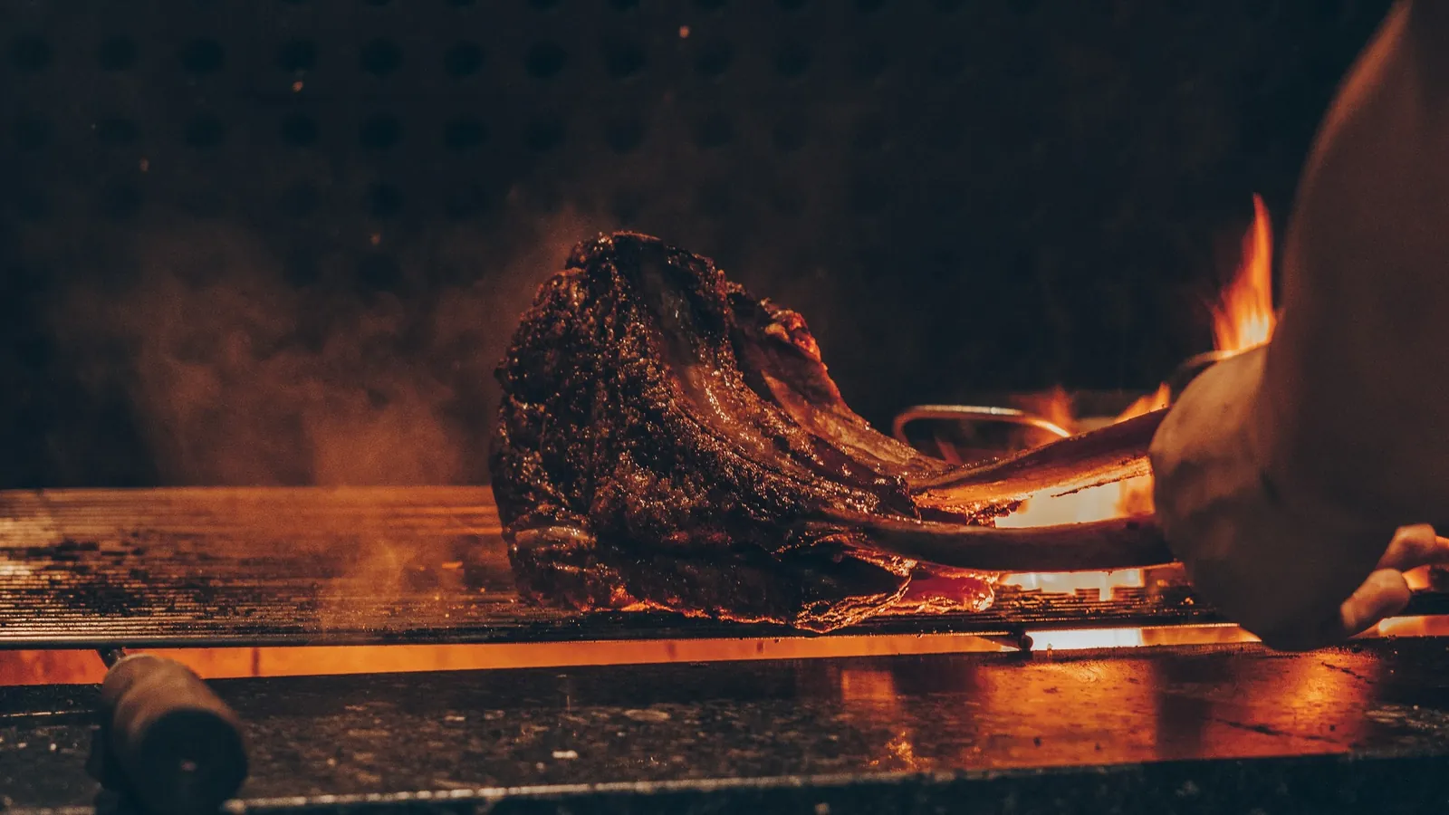 Tomahawk steak searing over an open wood fire