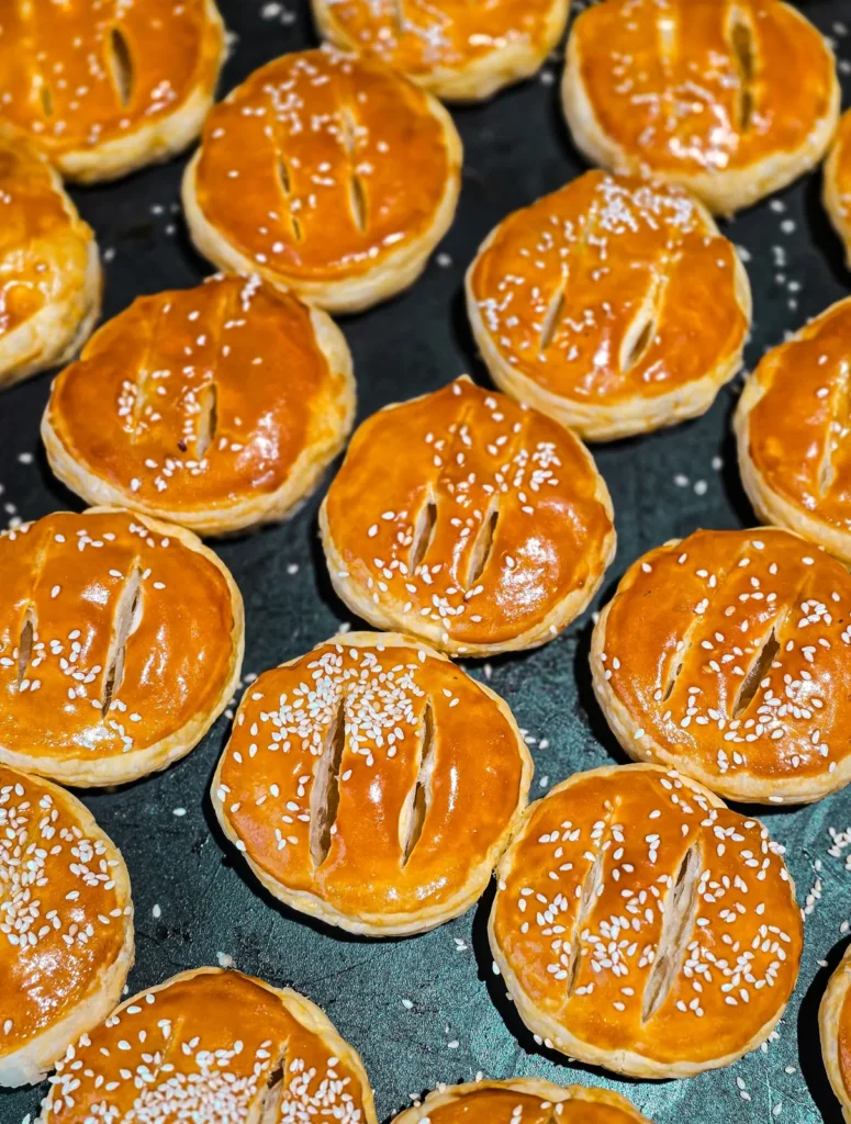 Glazed pastries with sesame on a tray