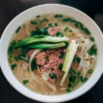 Rare beef pho with scallions, seen from above