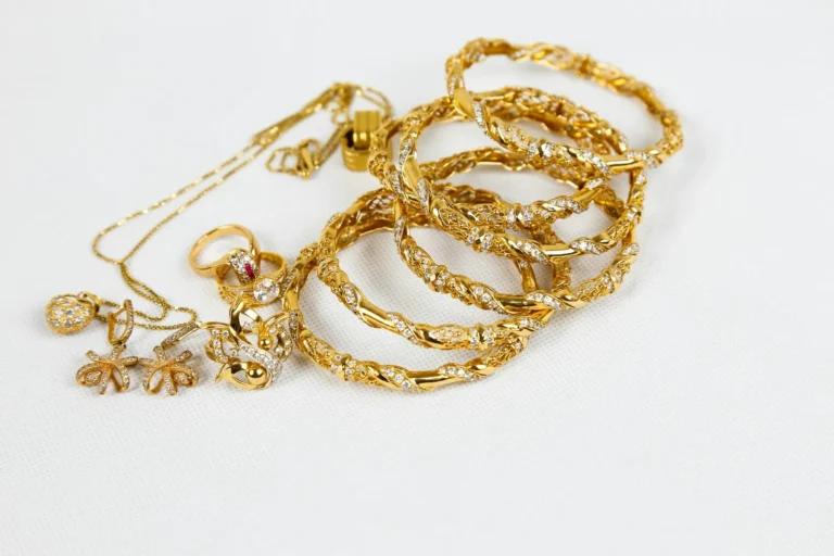 Gold bangles and a chain on white