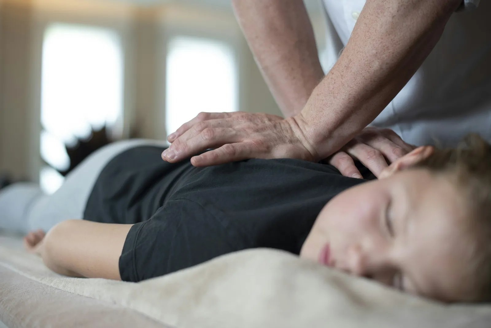 Gentle palm pressure on the upper back