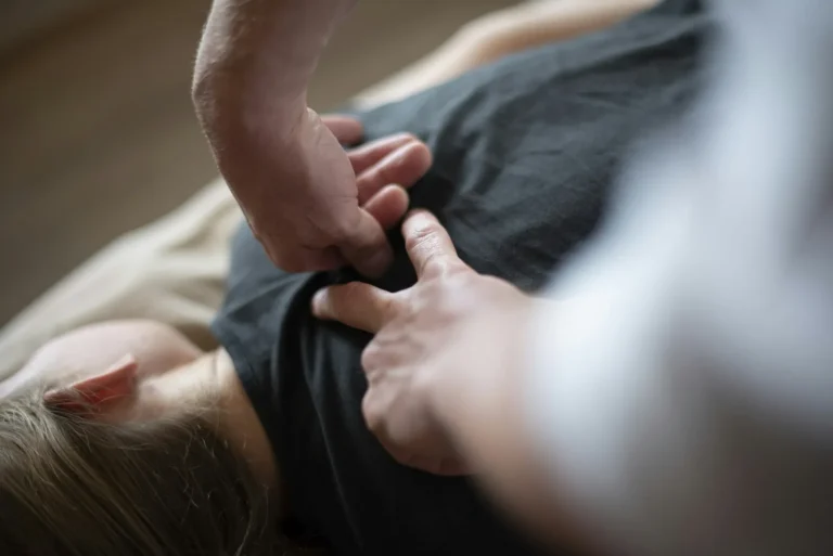 Thumb pressure beside the shoulder blade