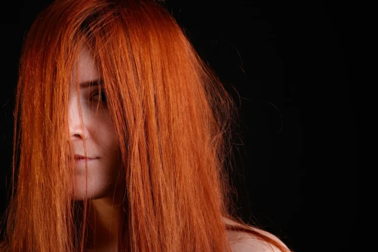 Bright copper hair against a black background