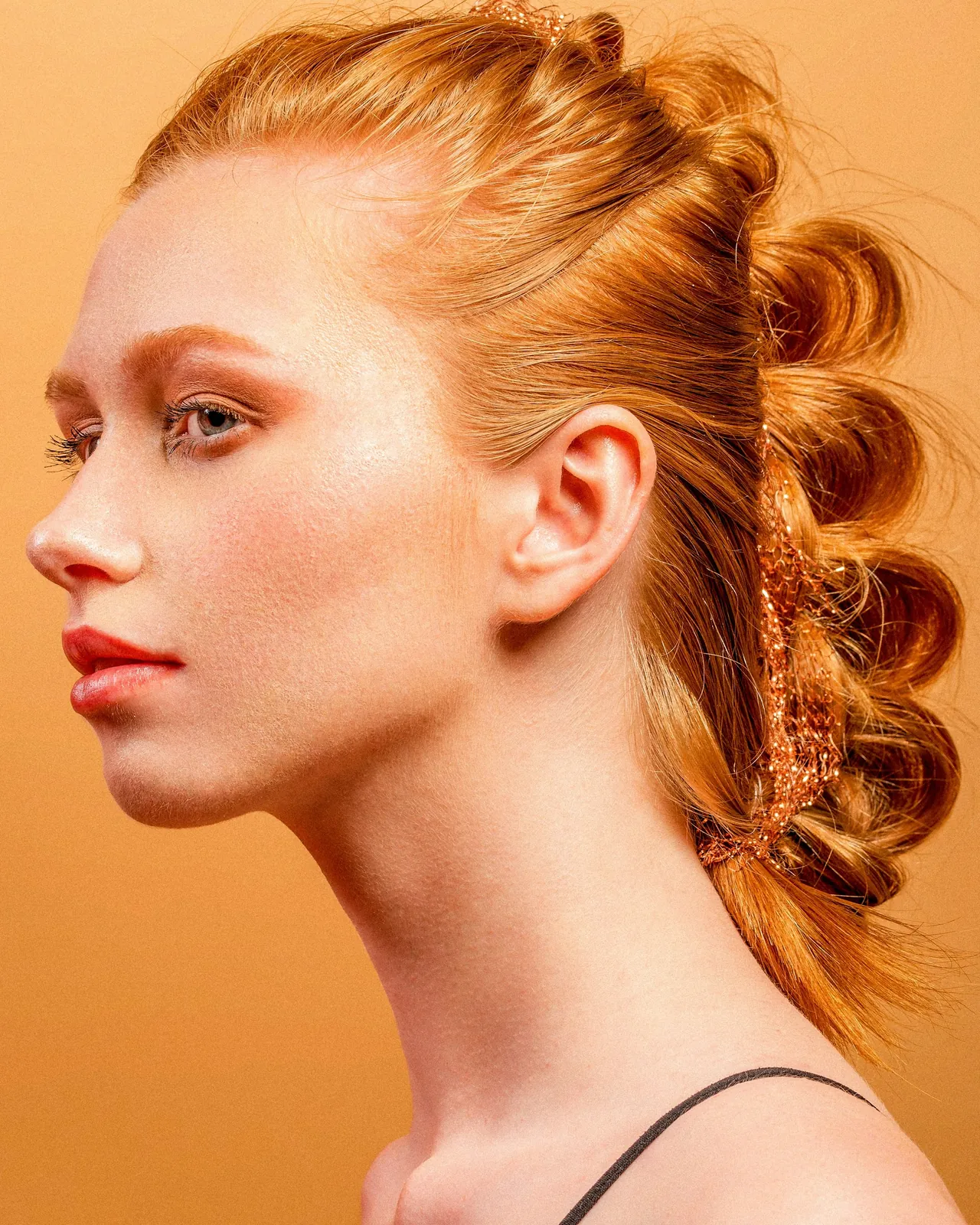 Profile of a woman with copper hair pinned in rolls