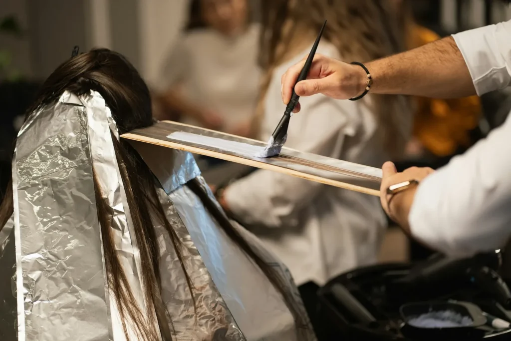 Colorist painting lightener onto foils