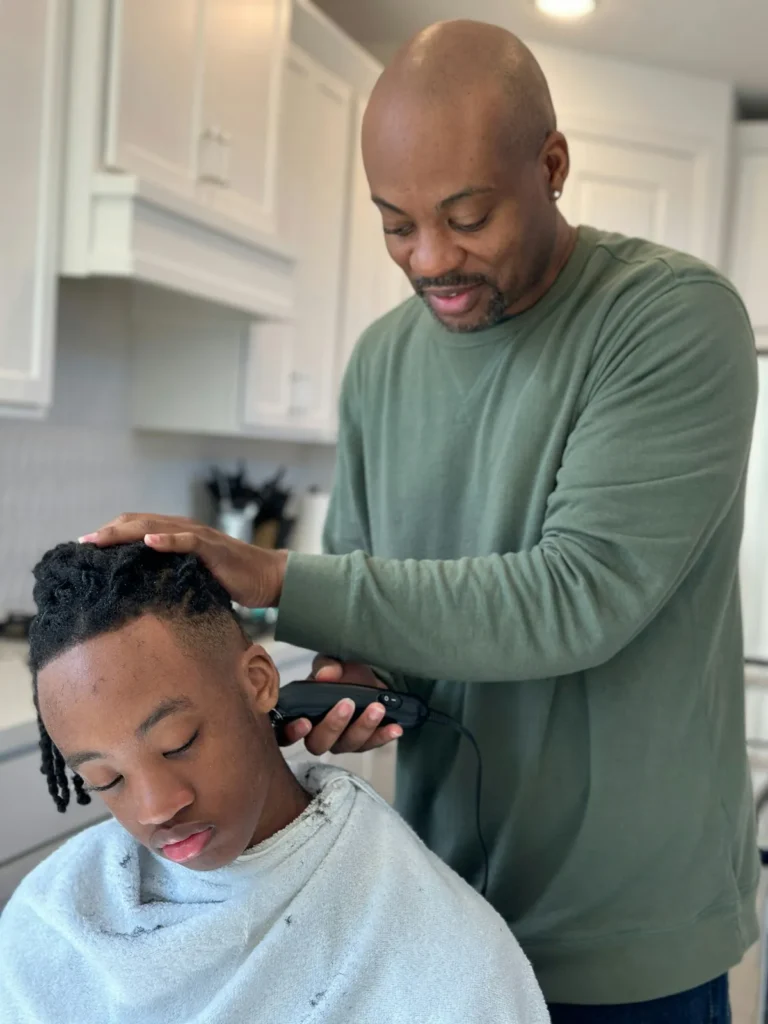 Father trimming his son's hair