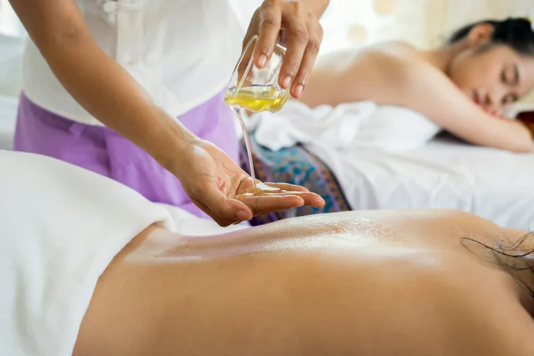 Therapist warming massage oil before a treatment