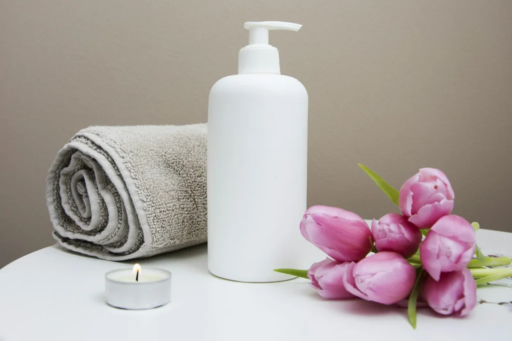 Rolled towel, body lotion and tulips