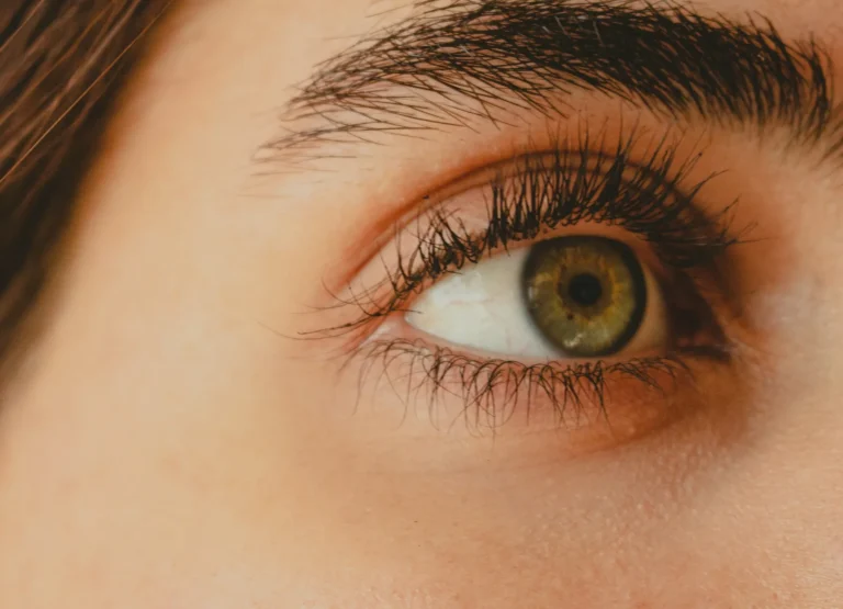 Natural lashes on a hazel eye in warm light