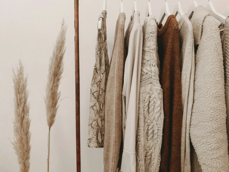 Neutral knitwear on a rail with pampas grass