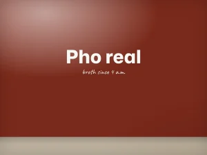White “Pho real” lettering on a pho restaurant’s red wall