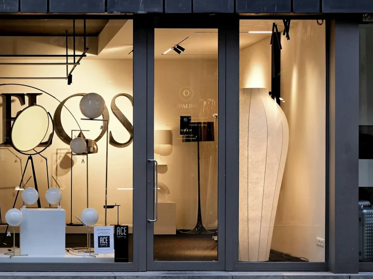 A gold door decal with logo, hours and phone on a nail salon’s glass door