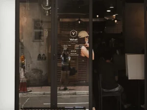 A white opening hours decal on dark glass
