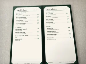 An open leather menu with two rigid inserts held at the corners