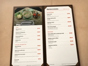 An open brown leather menu with a pho photo insert