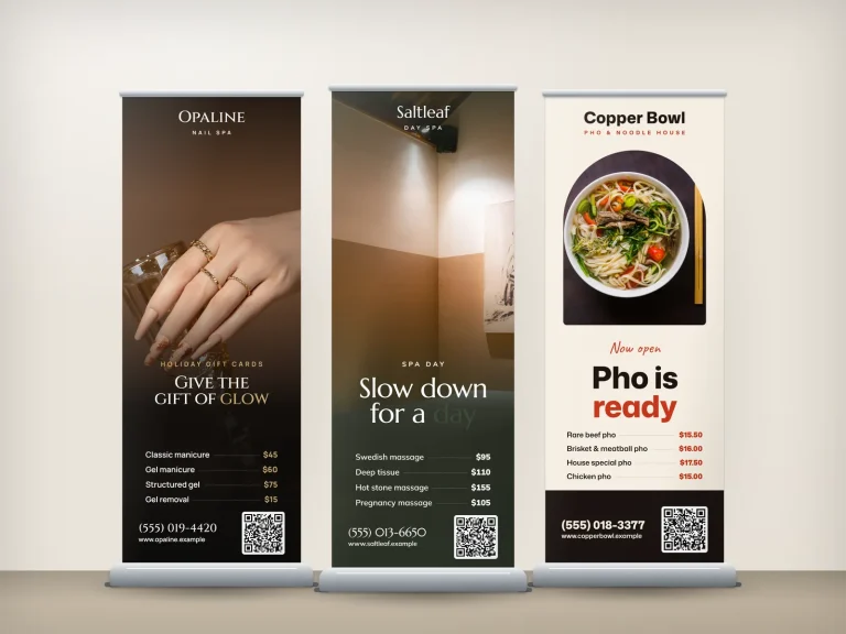 Three roll-up banners for a nail salon, a spa and a pho restaurant side by side
