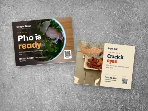 Yard signs for a pho restaurant and a seafood kitchen
