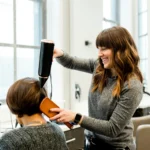 Hair stylist blow-drying a client's hair