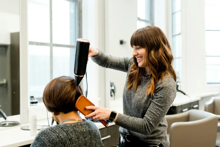 Hair stylist blow-drying a client's hair