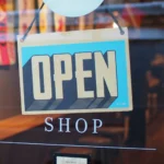 An OPEN sign hanging on a shop door